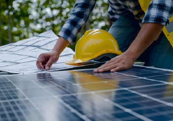 A worker is inspecting a solar panel